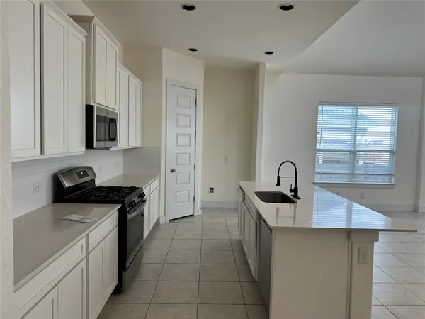a kitchen that has a sink and a stove top oven