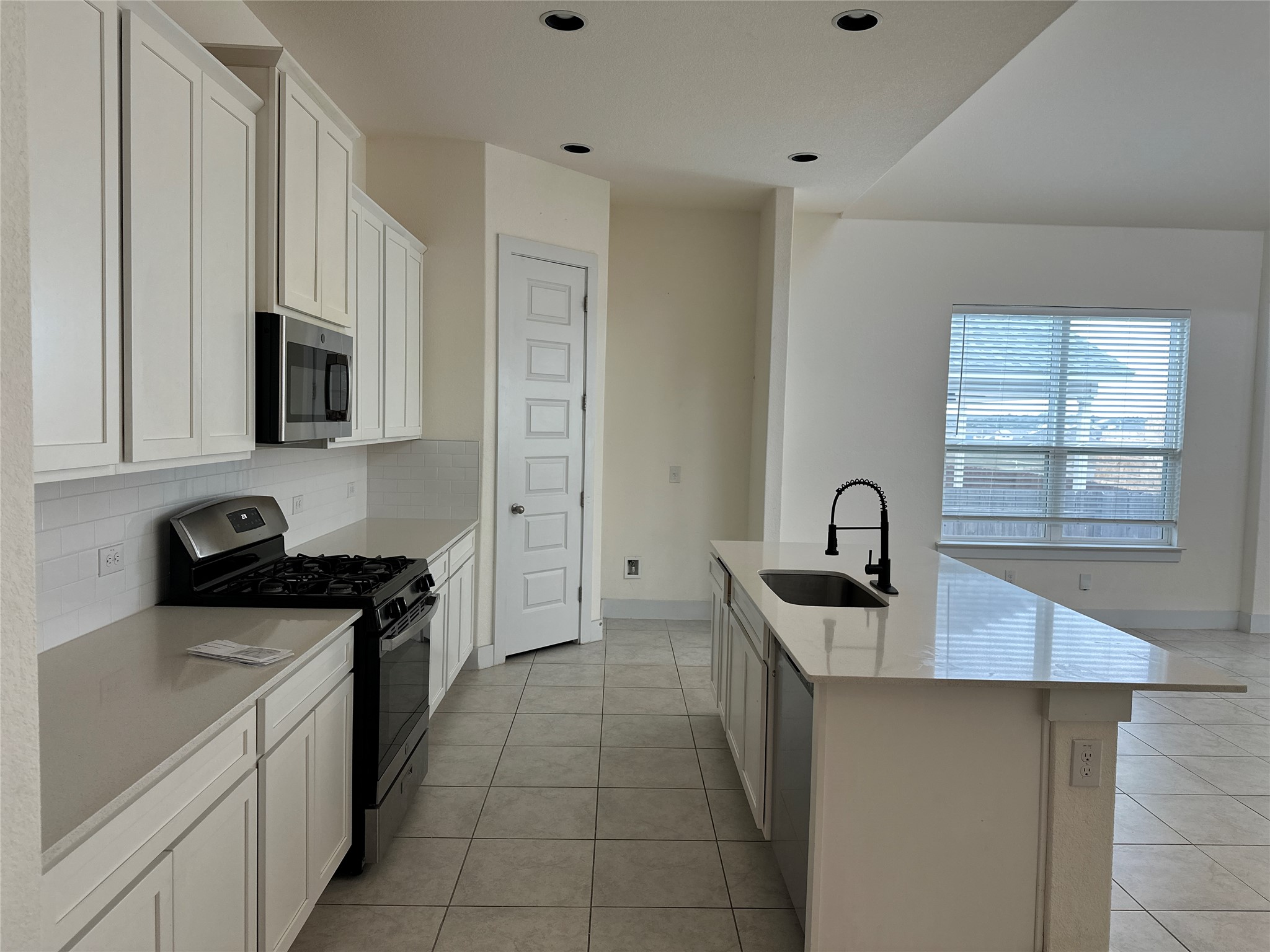 11204 Charger Way Manor, TX 78653 - Photo 8 of 21 a kitchen that has a sink and a stove top oven