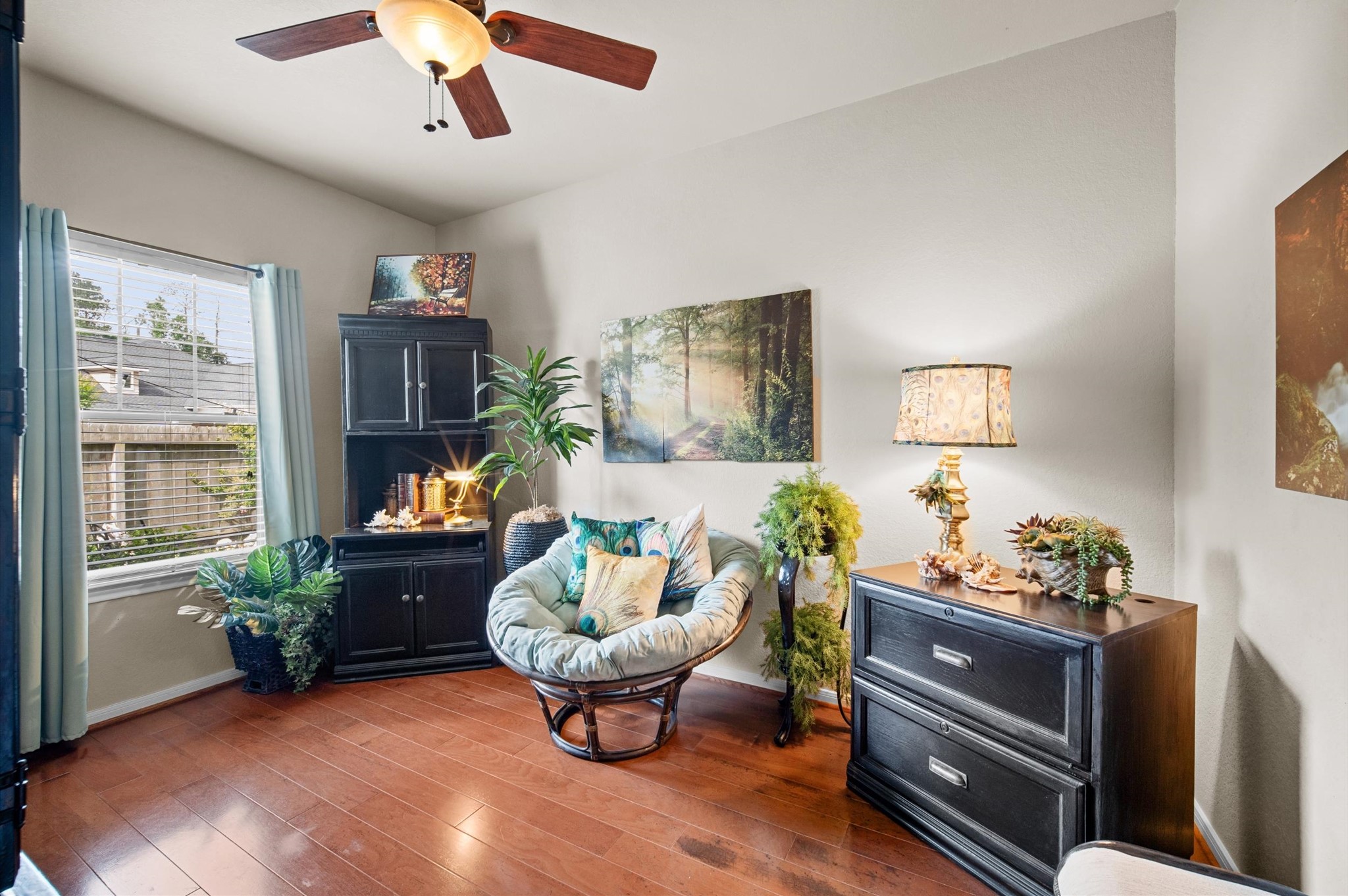 1603 Claytons Bend Court Spring, TX 77386 - Photo 14 of 38 This cozy room features warm wood flooring and a large window with natural light. The space is tastefully decorated with plants, a comfortable chair, and elegant furniture, creating a relaxing ambiance.