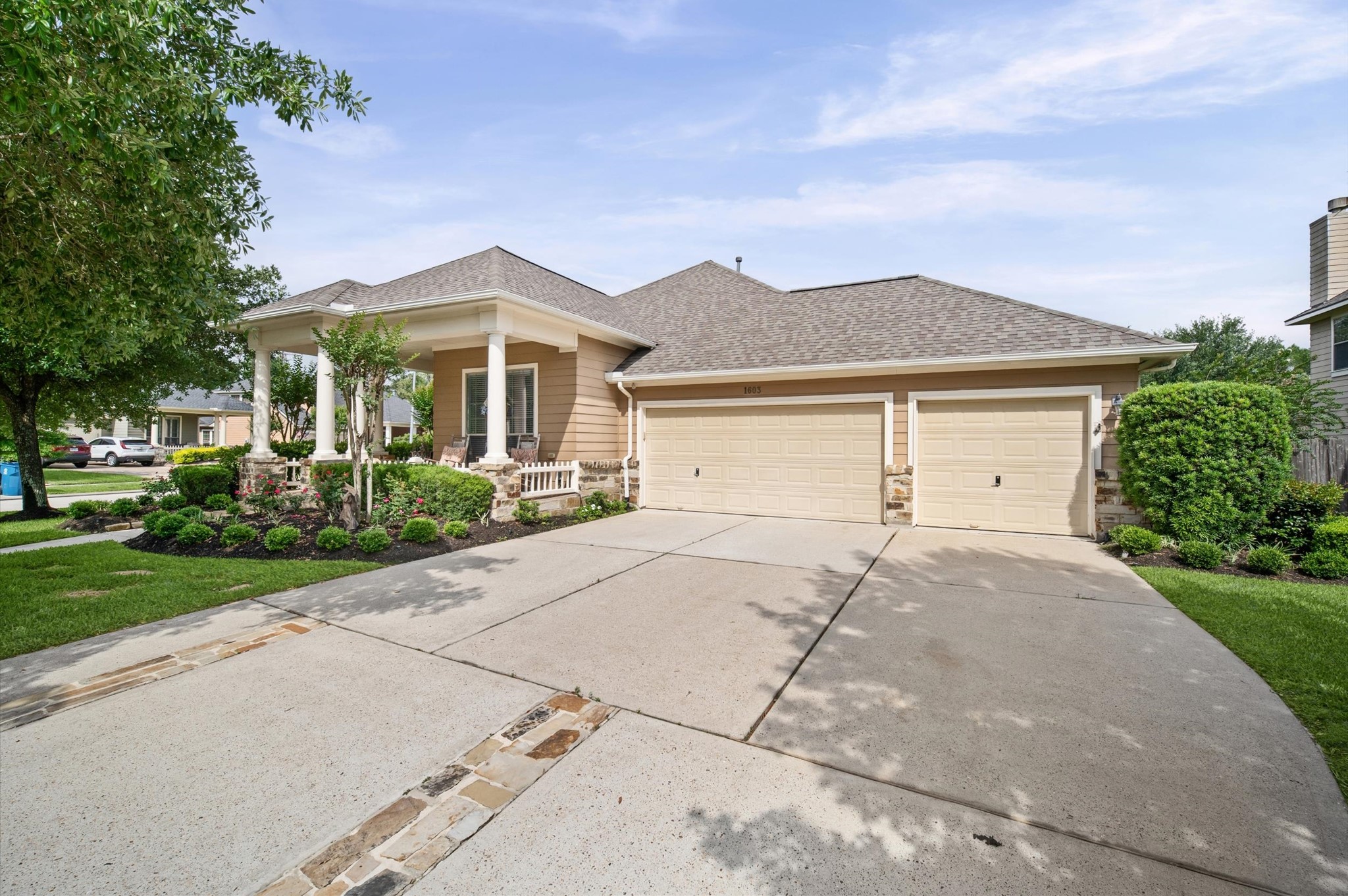1603 Claytons Bend Court Spring, TX 77386 - Photo 3 of 38 This inviting home features a well-maintained front yard with lush landscaping and a spacious driveway leading to a three-car garage. The exterior showcases a charming porch with columns and a neutral color palette, offering great curb appeal.