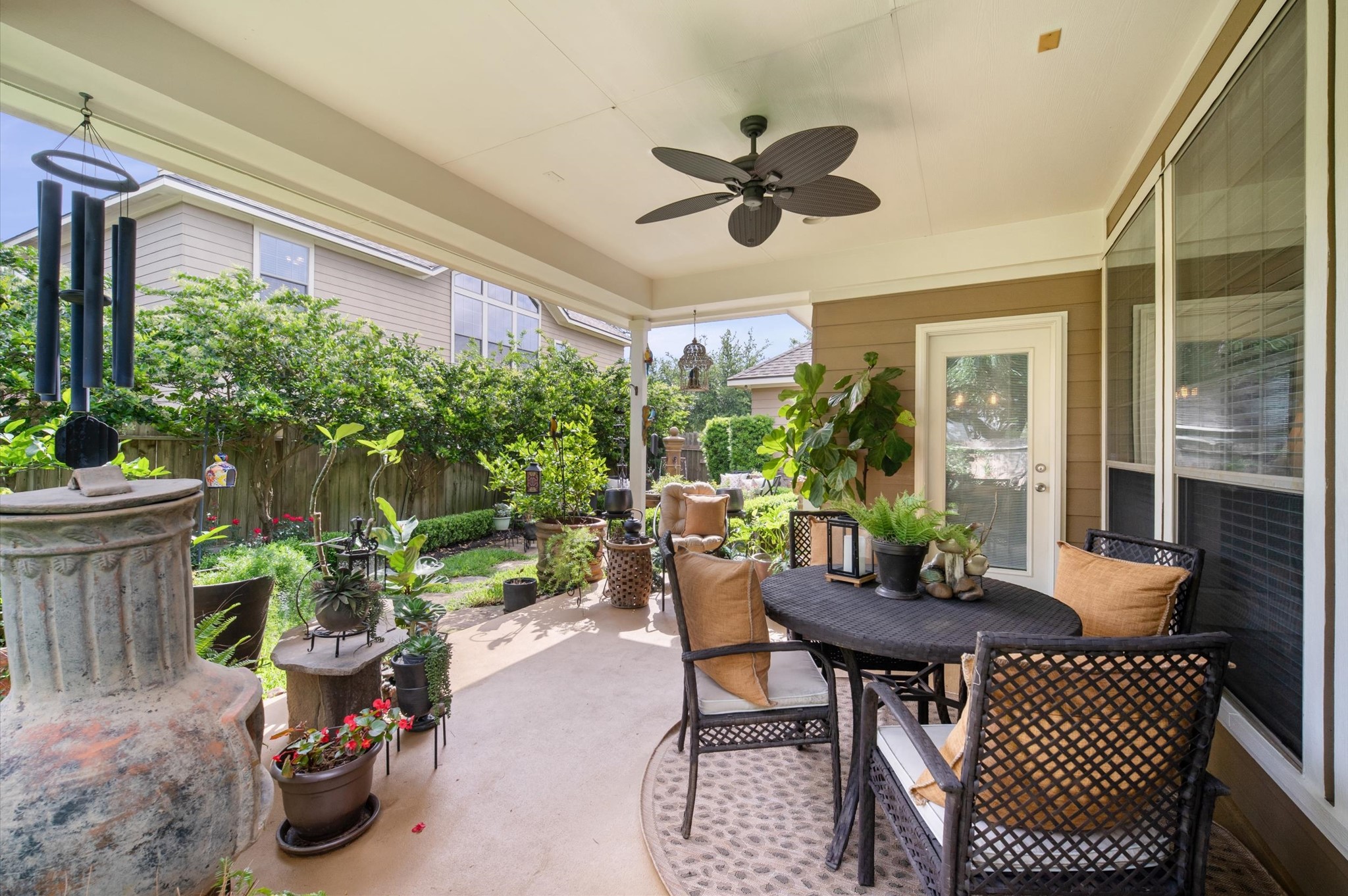 1603 Claytons Bend Court Spring, TX 77386 - Photo 32 of 38 This inviting covered patio features a ceiling fan, cozy seating, and lush greenery, offering a perfect space for relaxation and outdoor dining.