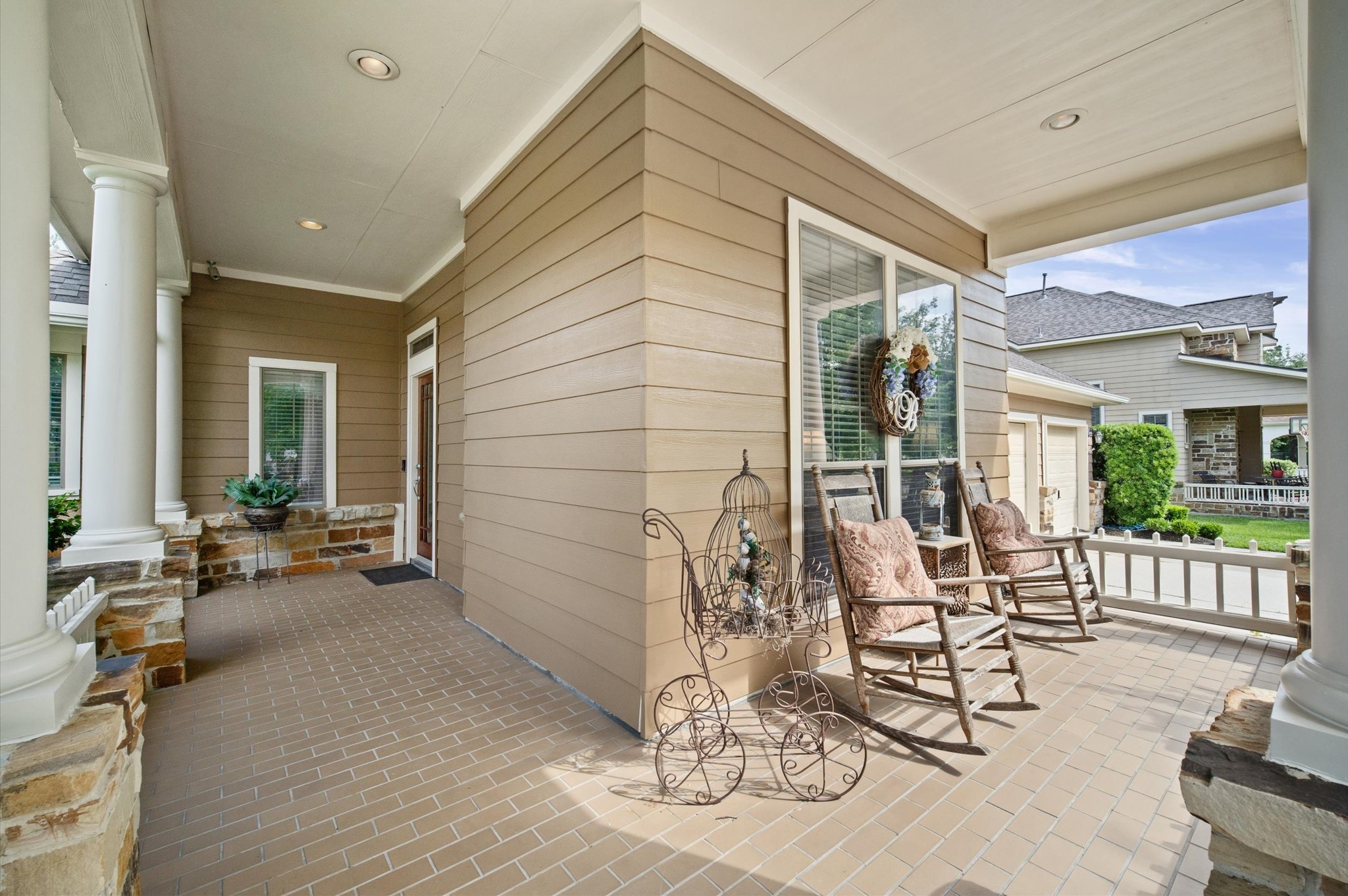 1603 Claytons Bend Court Spring, TX 77386 - Photo 36 of 38 Charming covered porch with warm-toned siding and brick flooring, featuring cozy rocking chairs and decorative accents. Ideal for relaxing and enjoying the outdoors.