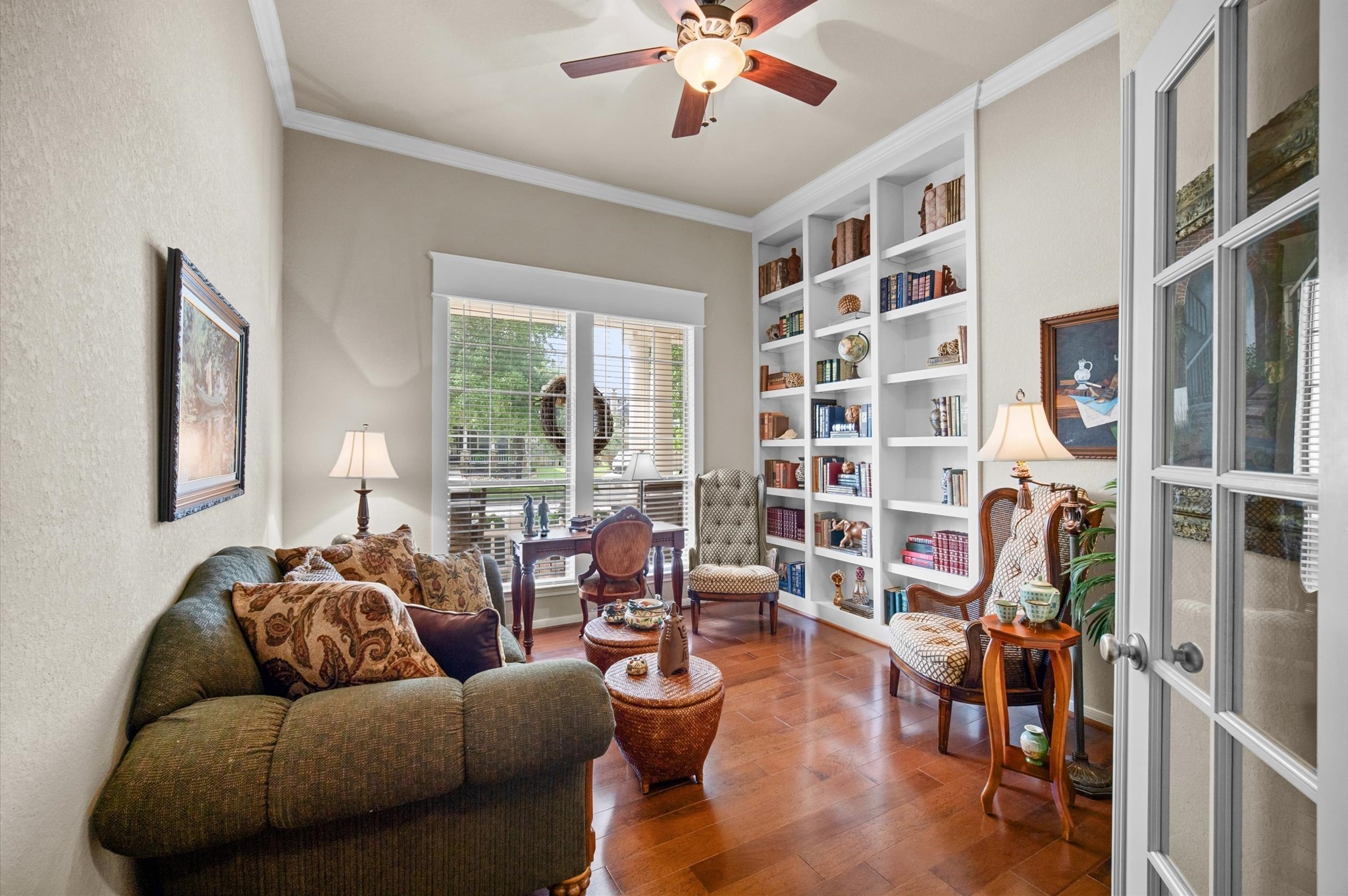 1603 Claytons Bend Court Spring, TX 77386 - Photo 7 of 38 This cozy study features elegant built-in bookshelves, hardwood floors, and ample natural light from large windows. The room is tastefully furnished with comfortable seating and classic decor, creating a perfect space for reading or working.