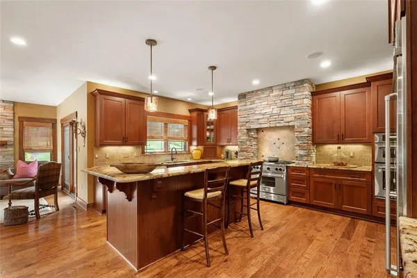 a kitchen with stainless steel appliances granite countertop a sink stove and refrigerator