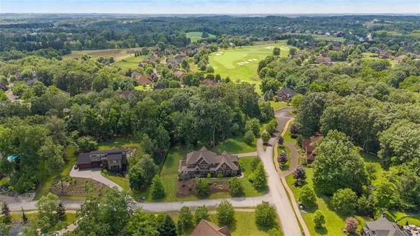 an aerial view of residential house with outdoor space and trees all around