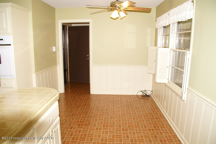 6117 Calumet Road Amarillo, TX 79106 - Photo 12 of 16 a view of a hallway with wooden floor and a bathroom