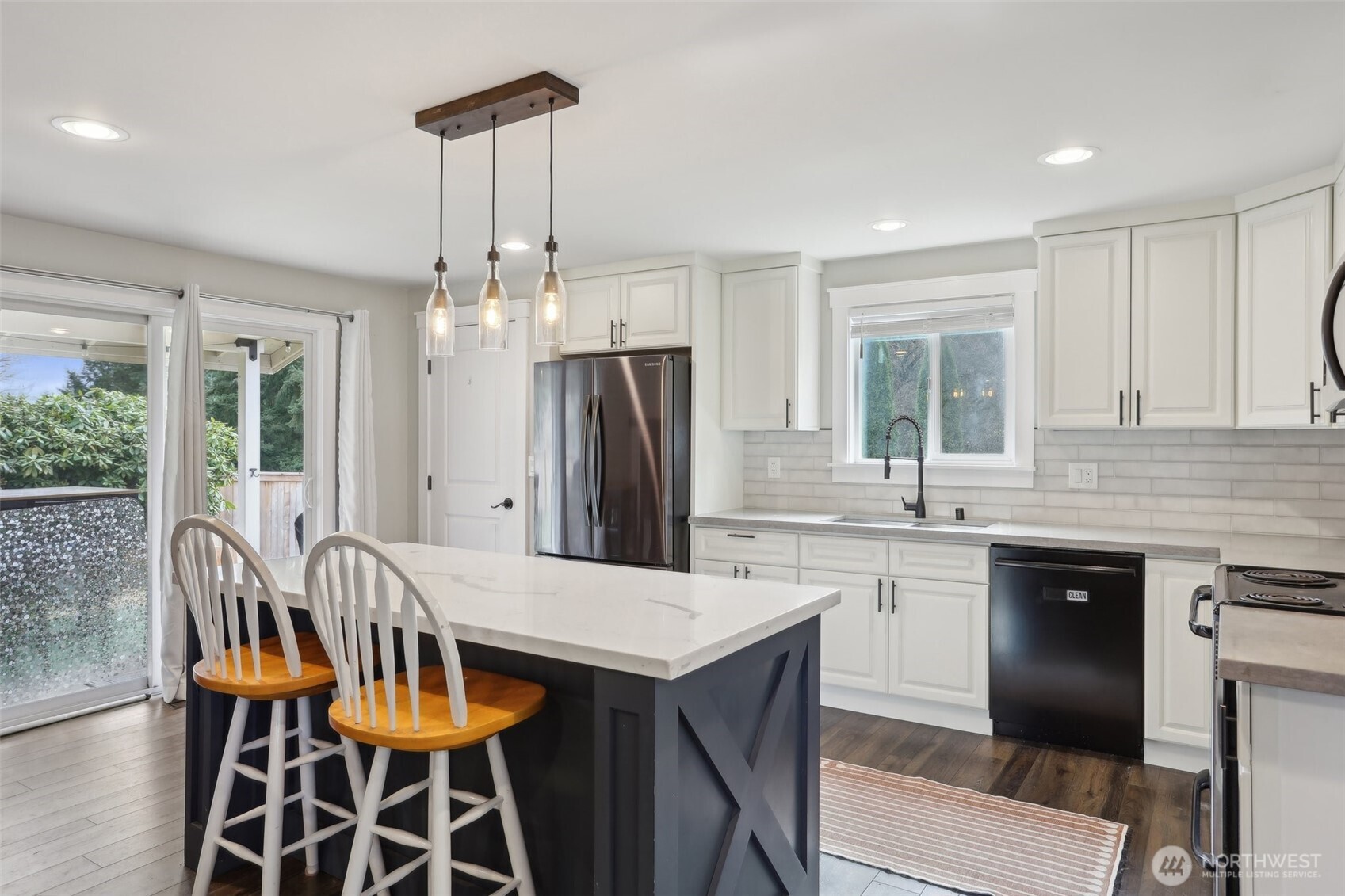 27713 Webster Road East Graham, WA 98338 - Photo 11 of 39 a kitchen with stainless steel appliances kitchen island granite countertop a dining table chairs and granite counter tops