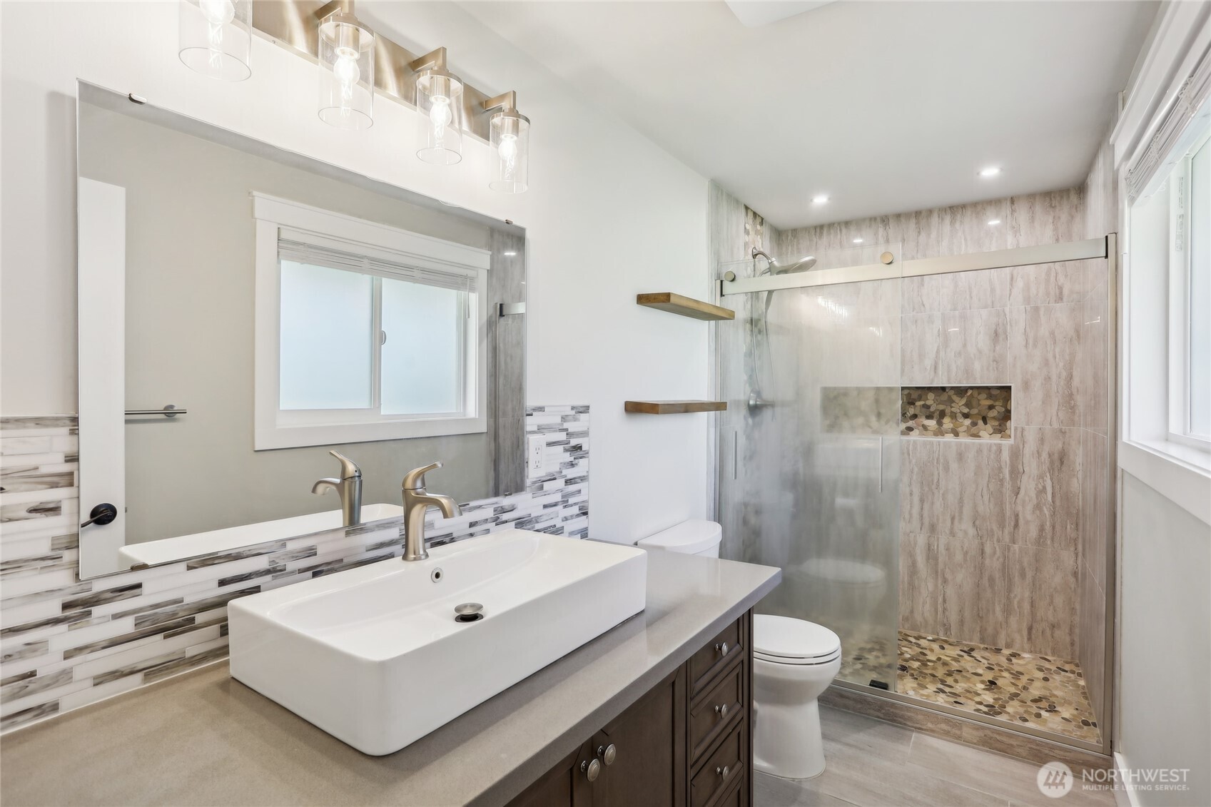 27713 Webster Road East Graham, WA 98338 - Photo 26 of 39 a bathroom with a sink toilet a mirror and shower