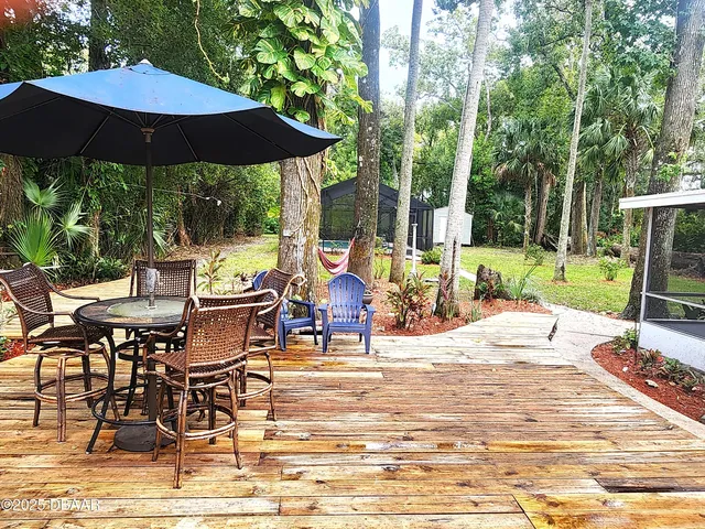 a view of a patio with table and chairs under an umbrella