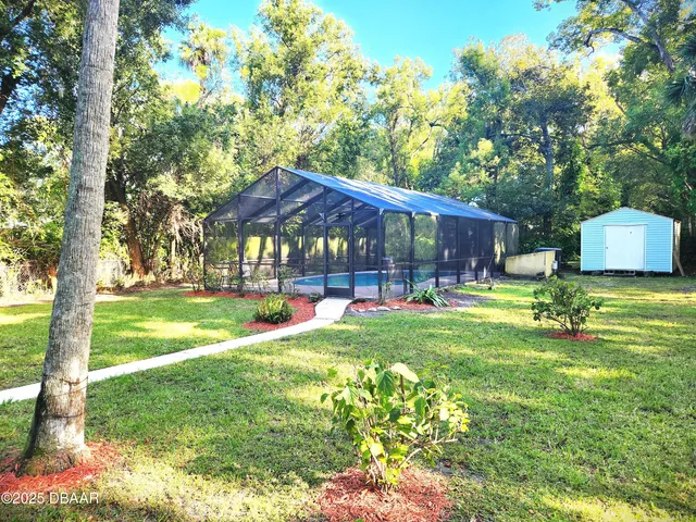 a view of a house with backyard and sitting area