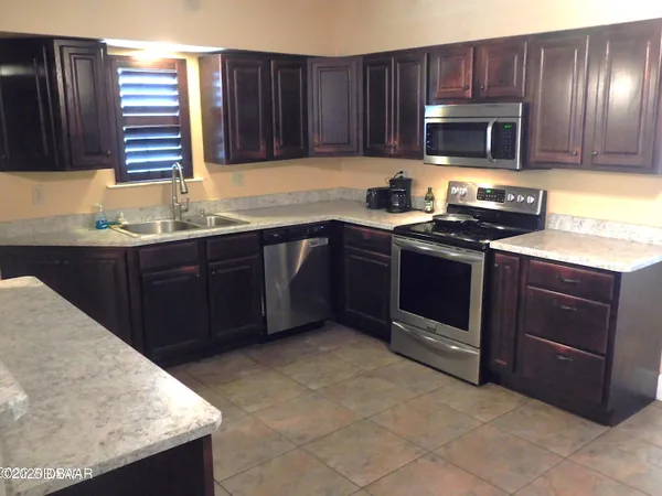 a kitchen with granite countertop wooden cabinets and stainless steel appliances