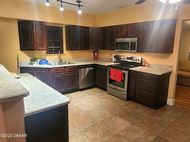 a kitchen with stainless steel appliances granite countertop wooden cabinets a stove top oven a sink and dishwasher