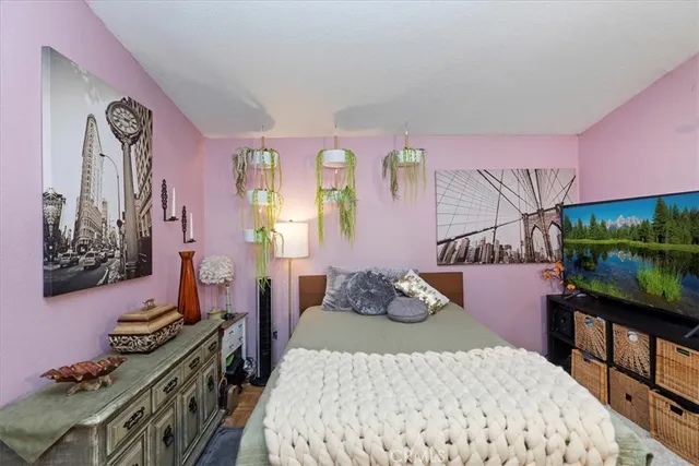 a bedroom with a bed and a flat tv screen on dresser