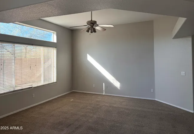 a view of a room with a ceiling fan and a window