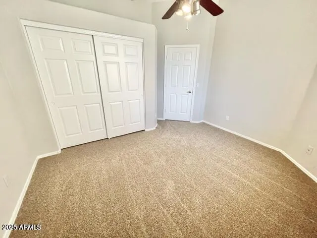 an empty room with chandelier fan