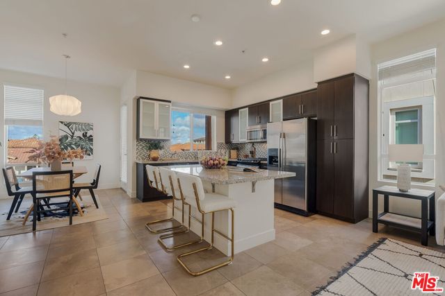 a large white kitchen with a large window and white stainless steel appliances