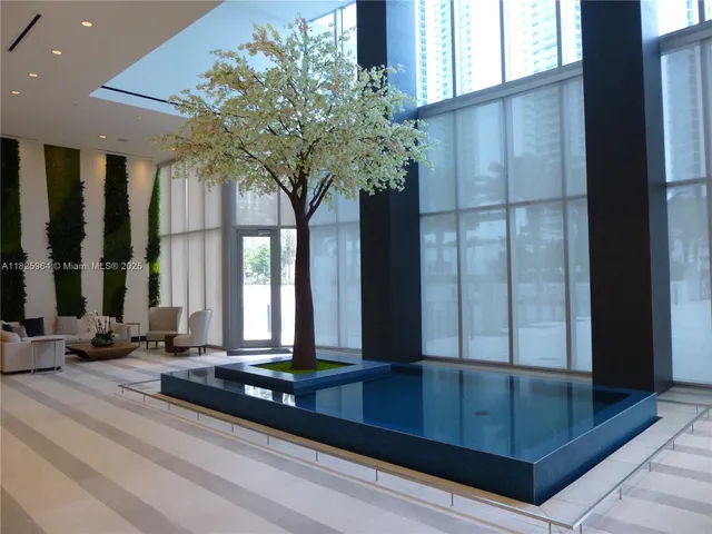 a view of a swimming pool with a lawn chairs and palm tree