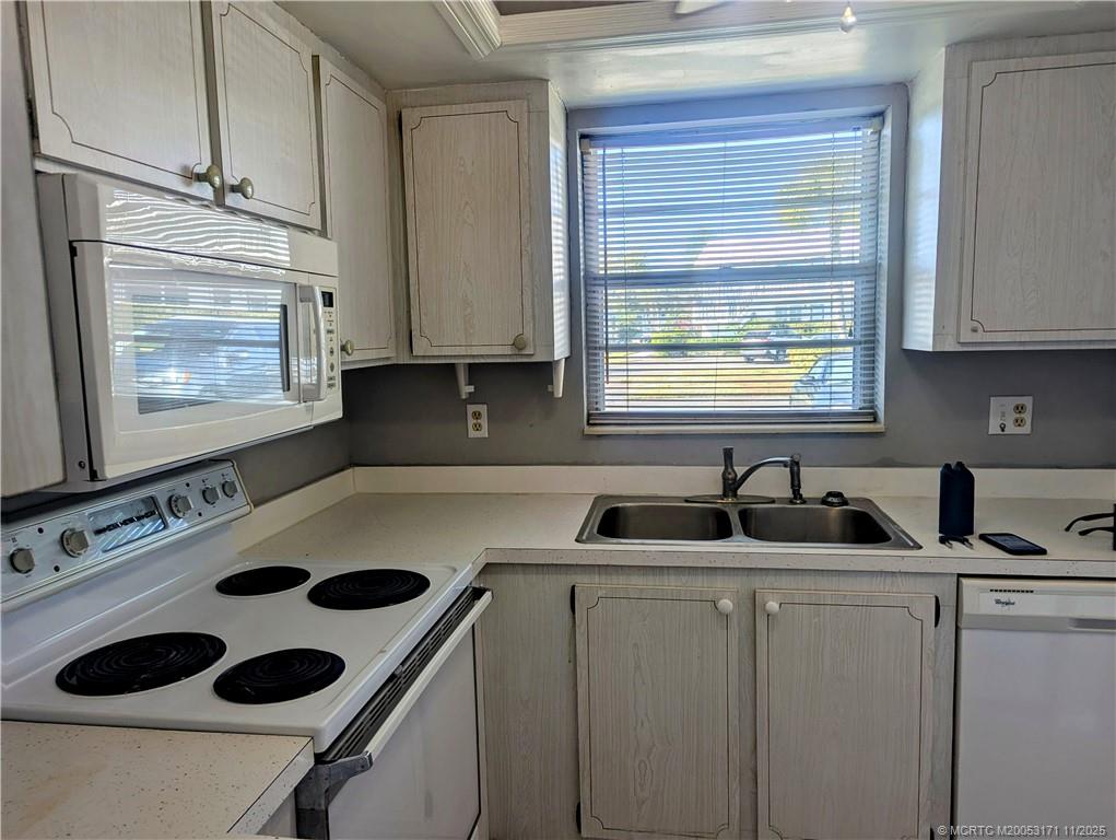2929 Southeast Ocean Boulevard, Unit 1393 Stuart, FL 34996 - Photo 3 of 9 a kitchen with a sink a stove and cabinets