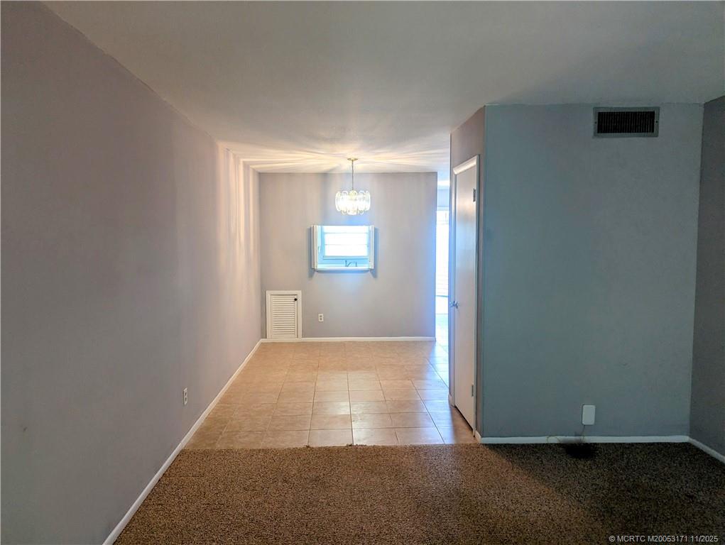 2929 Southeast Ocean Boulevard, Unit 1393 Stuart, FL 34996 - Photo 8 of 9 an empty room with wooden floor and windows