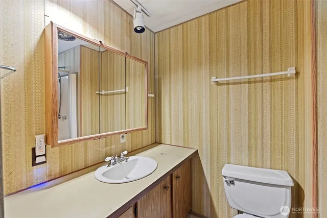 a bathroom with a sink a toilet and shower