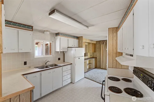 a kitchen with a sink a refrigerator and cabinets