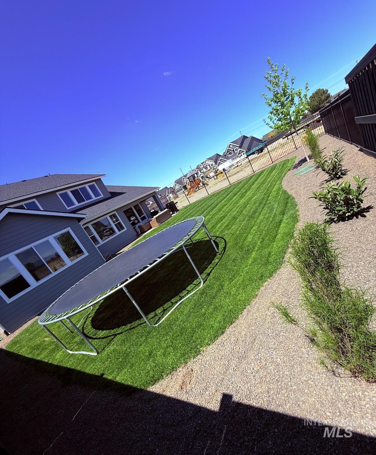 6548 South Utmost Lane Meridian, ID 83642 - Photo 3 of 3 Fenced backyard featuring a trampoline, a patio area, and a residential view