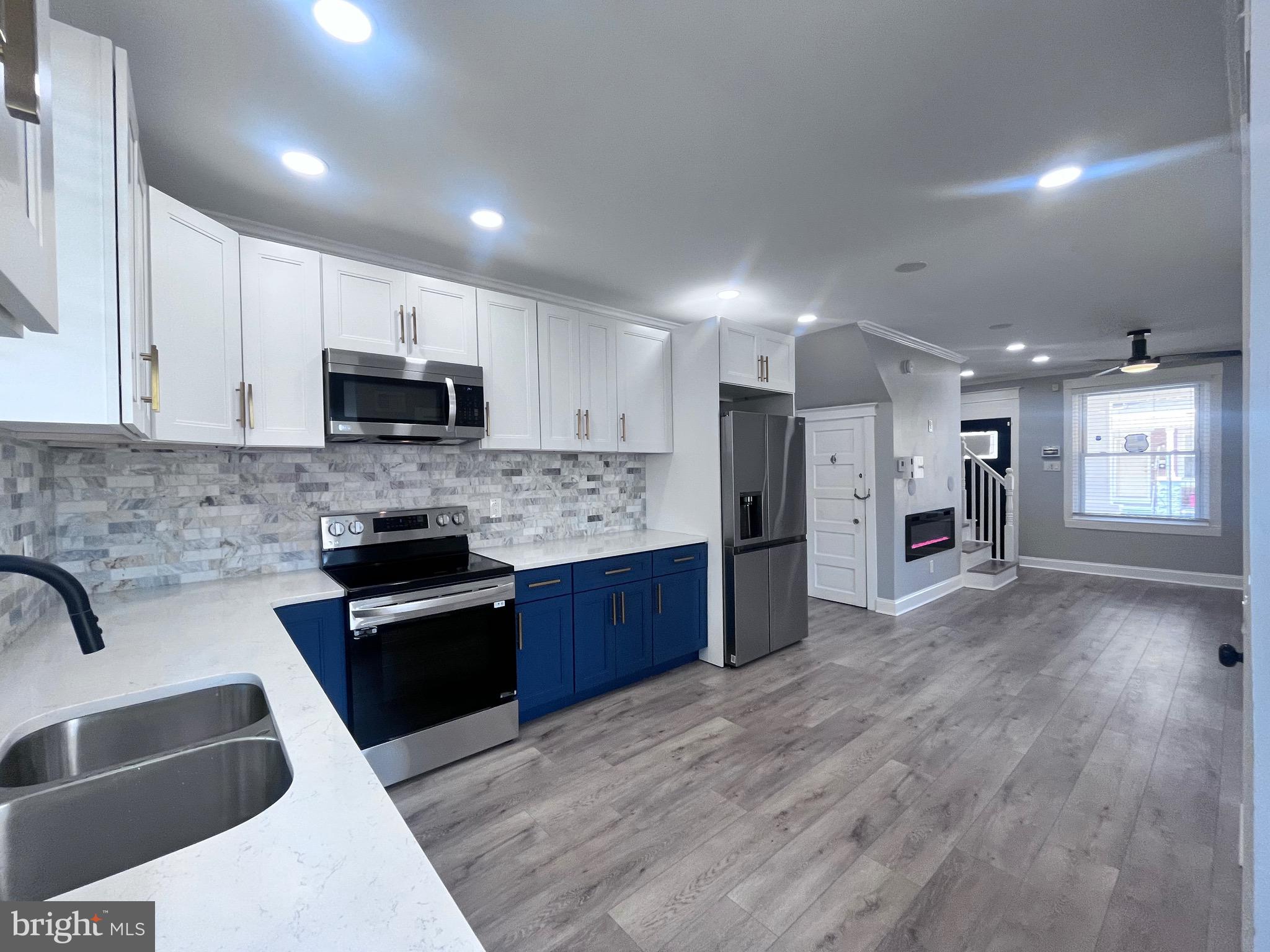 2520 West Seybert Street Philadelphia, PA 19121 - Photo 19 of 40 a large kitchen with stainless steel appliances kitchen island granite countertop a stove a sink a refrigerator and a microwave