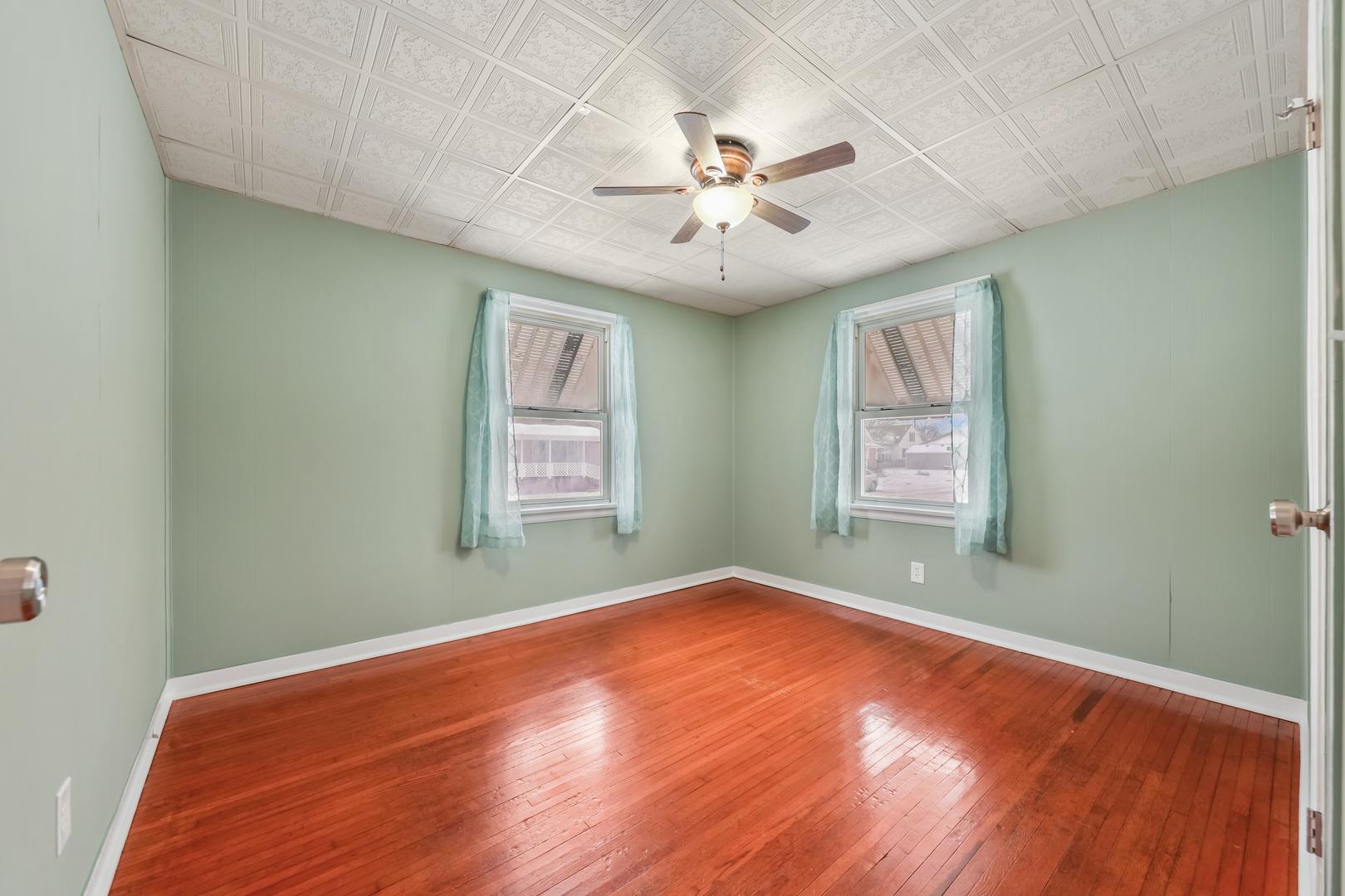 1428 Pickwick Street Ottawa, IL 61350 - Photo 12 of 14 an empty room with wooden floor chandelier fan and windows