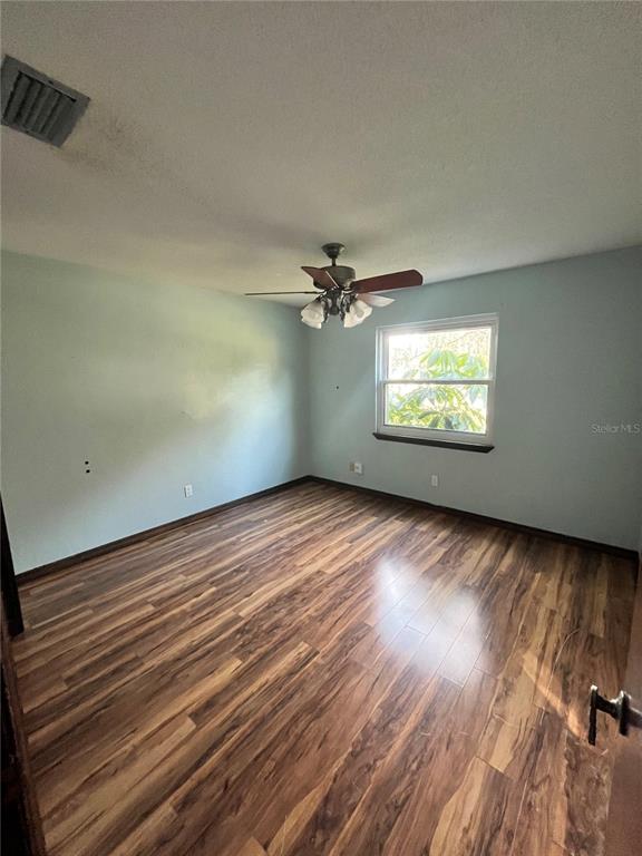 941 Mill Rd Lane Port Orange, FL 32127 - Photo 15 of 24 an empty room with wooden floor chandelier and windows