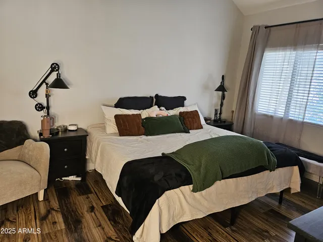 a bedroom with a bed and a flat tv screen on the dresser