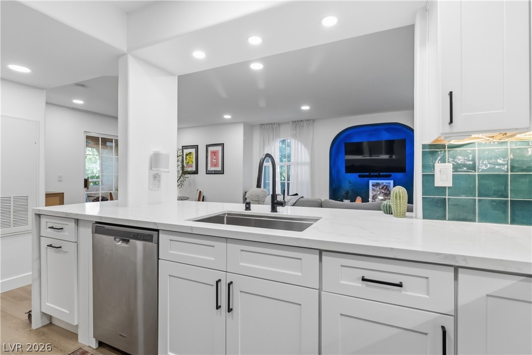 7950 West Flamingo Road, Unit 1180 Las Vegas, NV 89147 - Photo 13 of 26 A contemporary kitchen features bright white cabinetry and a convenient pass-through window to the living area.