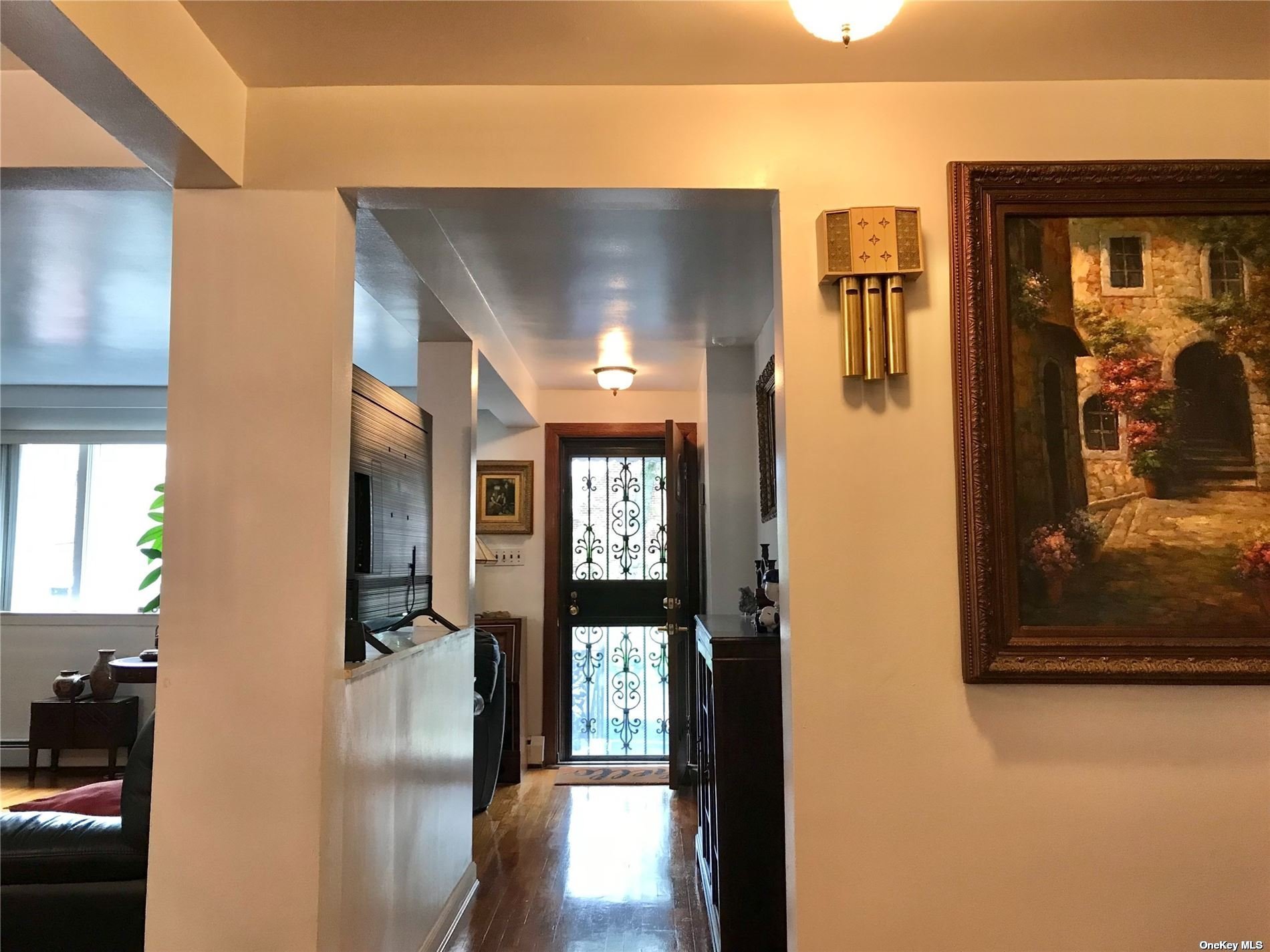 170-15 84th Drive Queens, NY 11432 - Photo 5 of 15 a view of a hallway with wooden floor and a living room