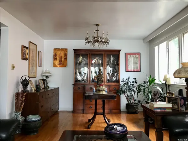 a living room with furniture a chandelier and a window