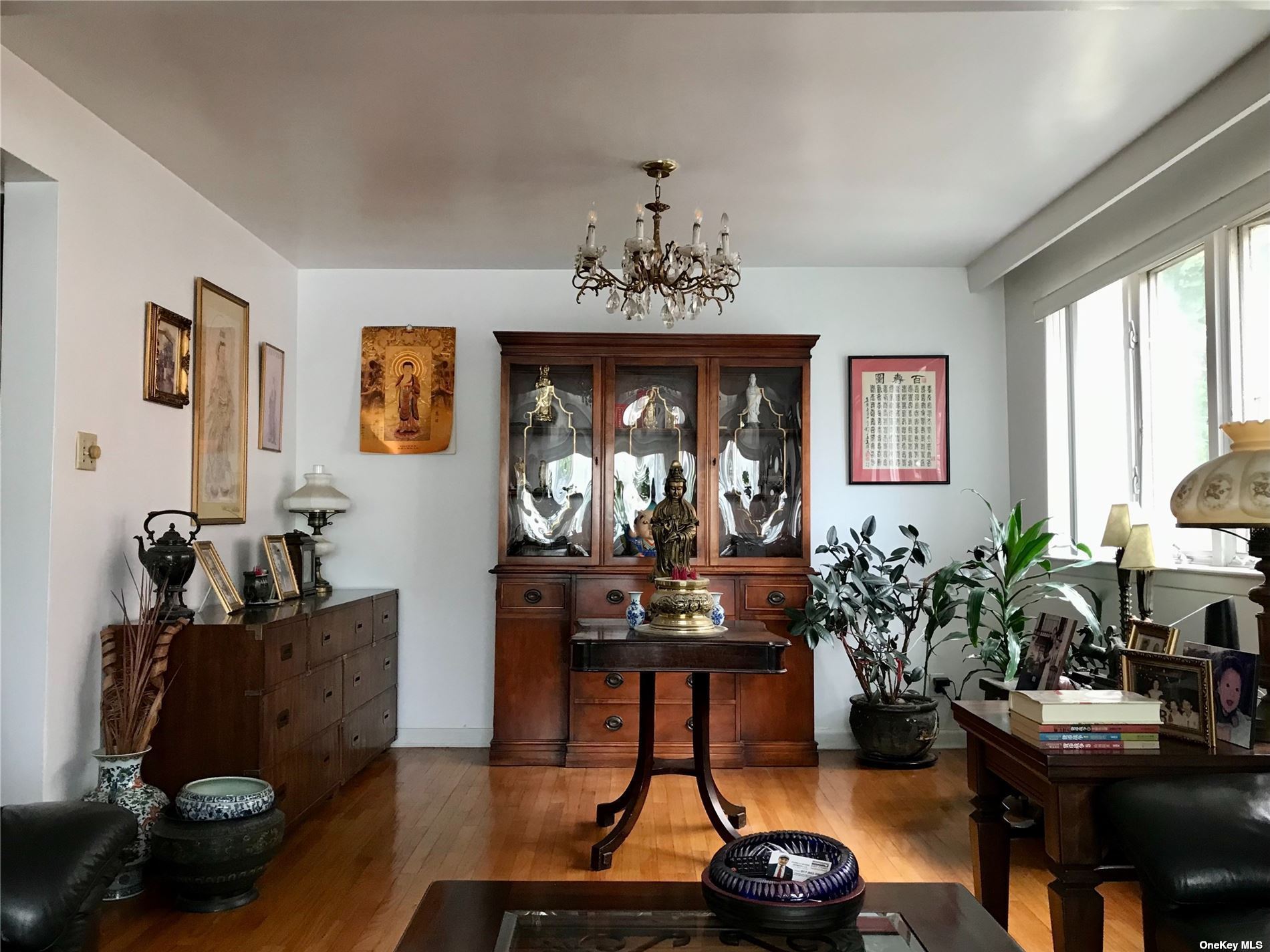 170-15 84th Drive Queens, NY 11432 - Photo 6 of 15 a living room with furniture a chandelier and a window