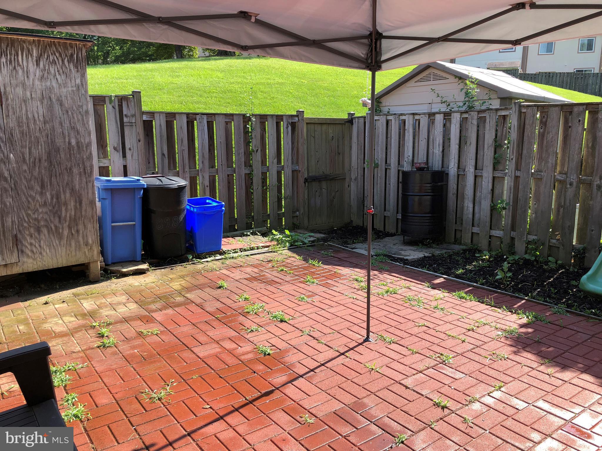 8989 Centerway Road Gaithersburg, MD 20879 - Photo 2 of 26 a view of a backyard with a small cabin and wooden fence