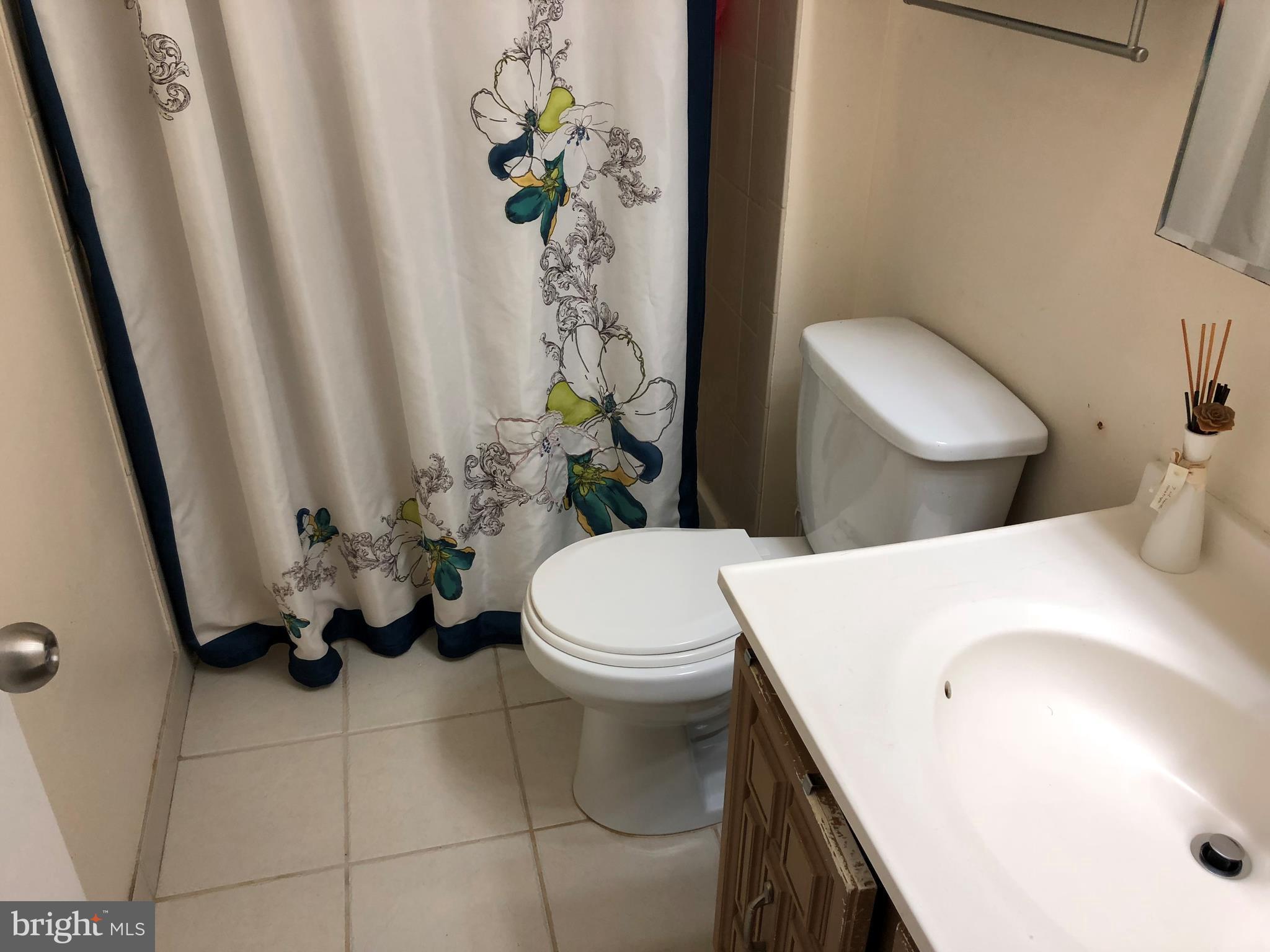 8989 Centerway Road Gaithersburg, MD 20879 - Photo 11 of 26 a bathroom with a sink a toilet and a shower curtain