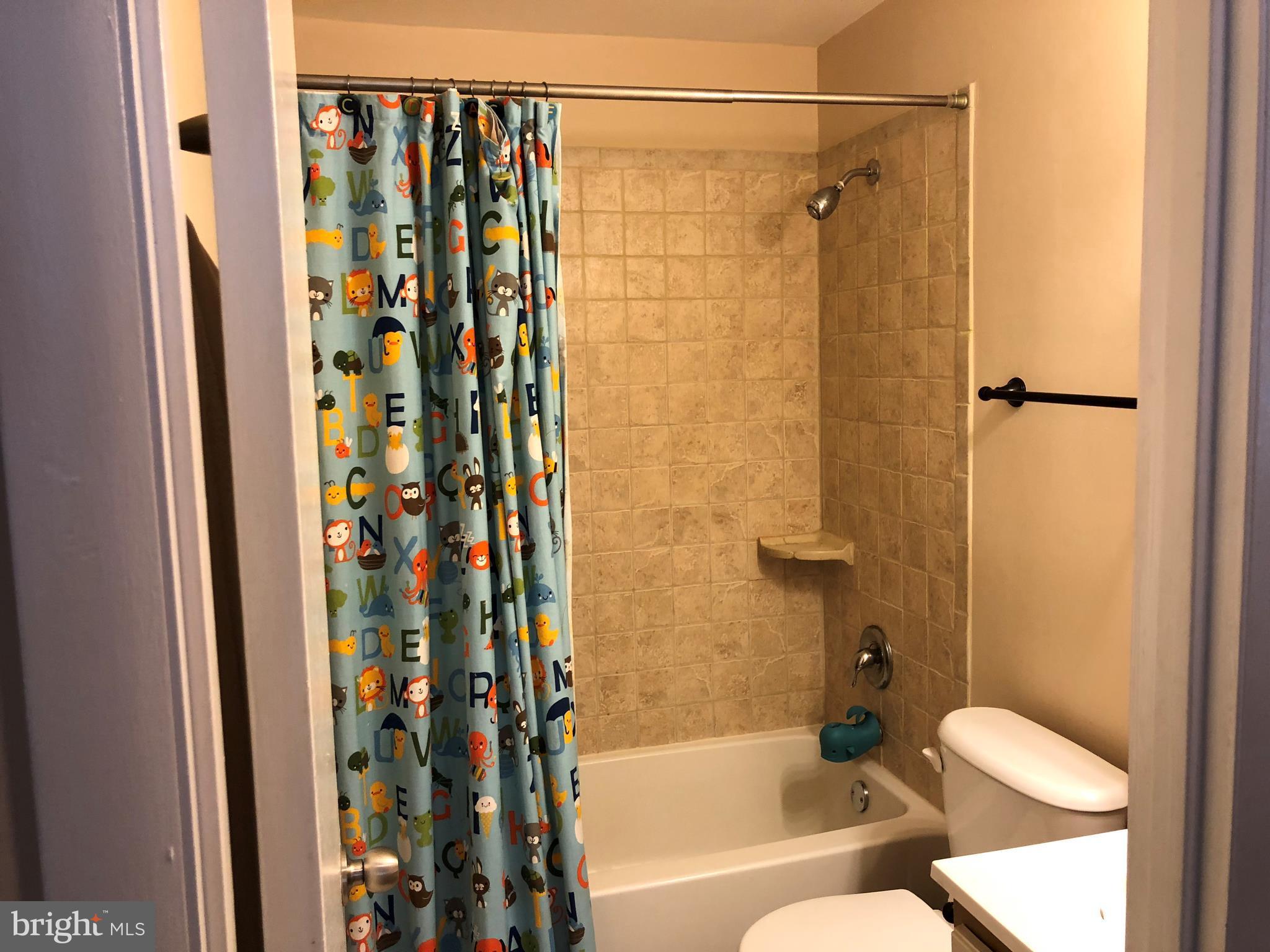 8989 Centerway Road Gaithersburg, MD 20879 - Photo 12 of 26 a bathroom with a shower curtain and a sink
