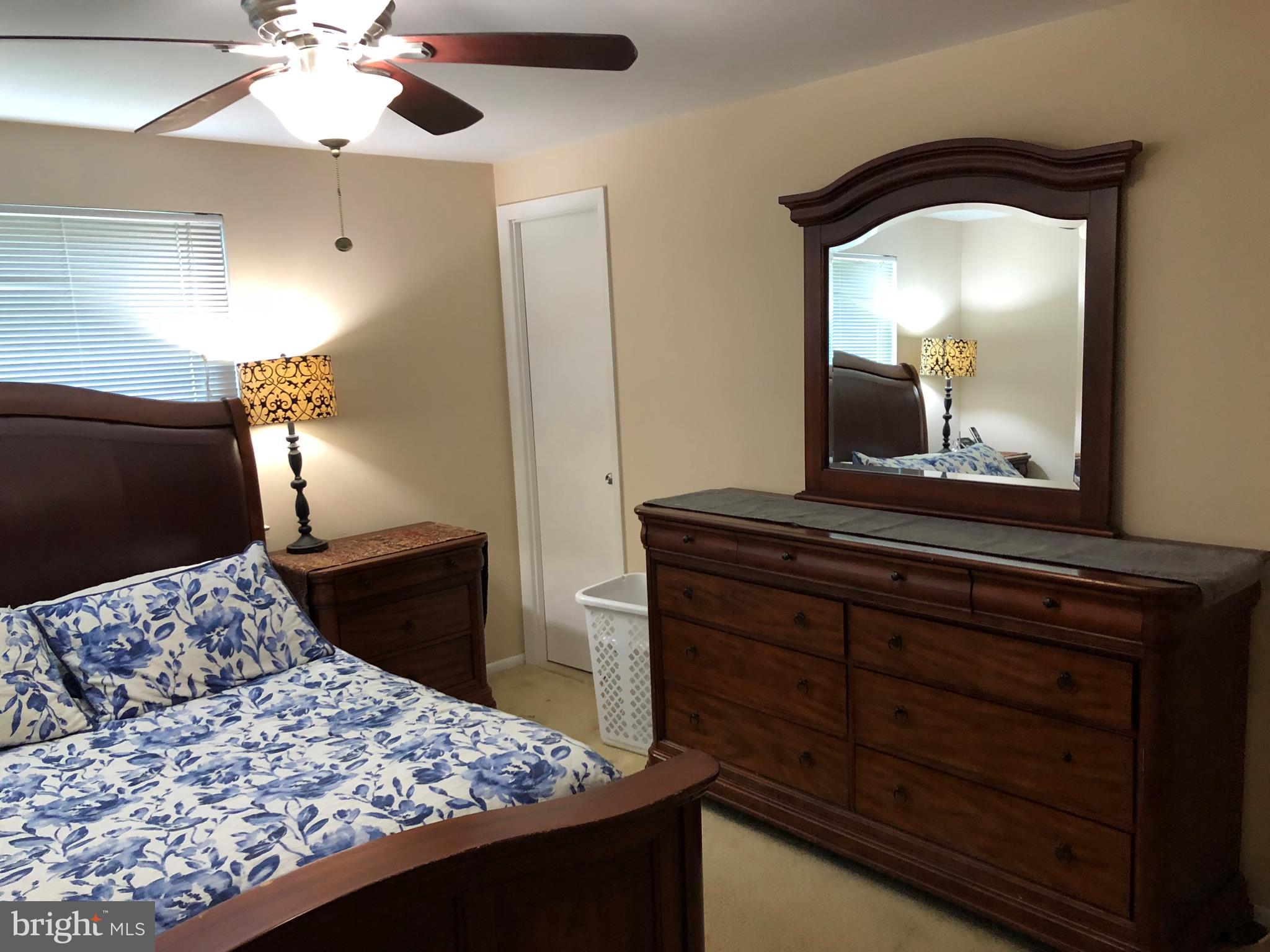 8989 Centerway Road Gaithersburg, MD 20879 - Photo 4 of 26 a bedroom with a bed and a mirror on the dresser