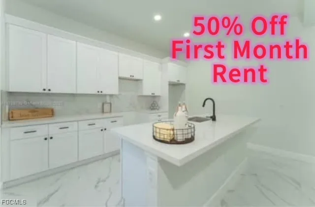 a kitchen with a sink a stove and cabinets