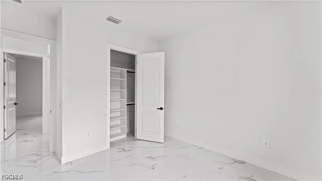 an empty room with closet and mirror