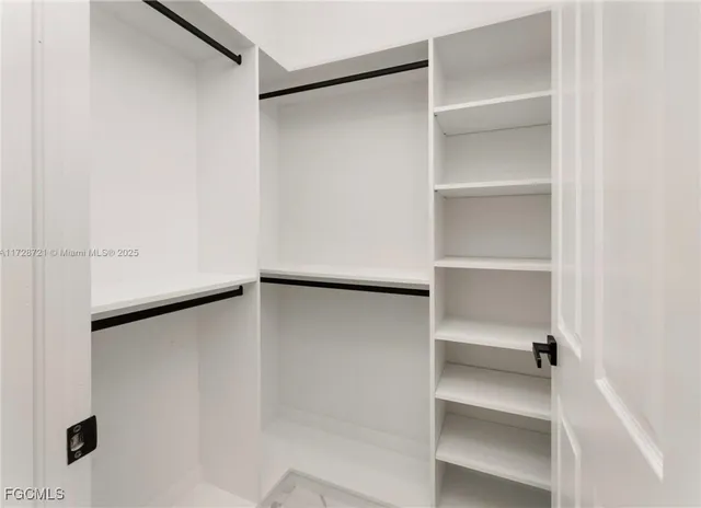 an empty room with fan and entrance