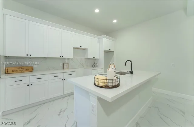 a kitchen with sink a stove and cabinets