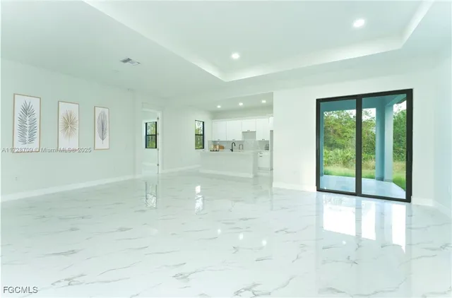 a large white kitchen with kitchen island a sink a stove and a refrigerator