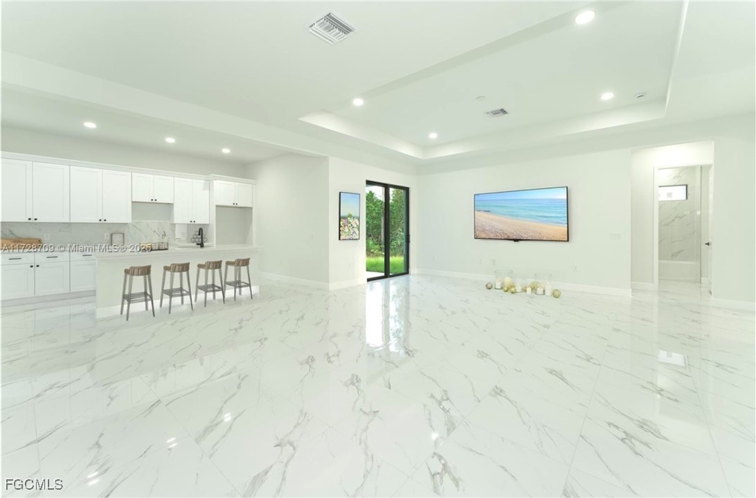 729 Giorgio Avenue Lehigh Acres, FL 33974 - Photo 9 of 21 a large white kitchen with kitchen island a sink a stove and a refrigerator