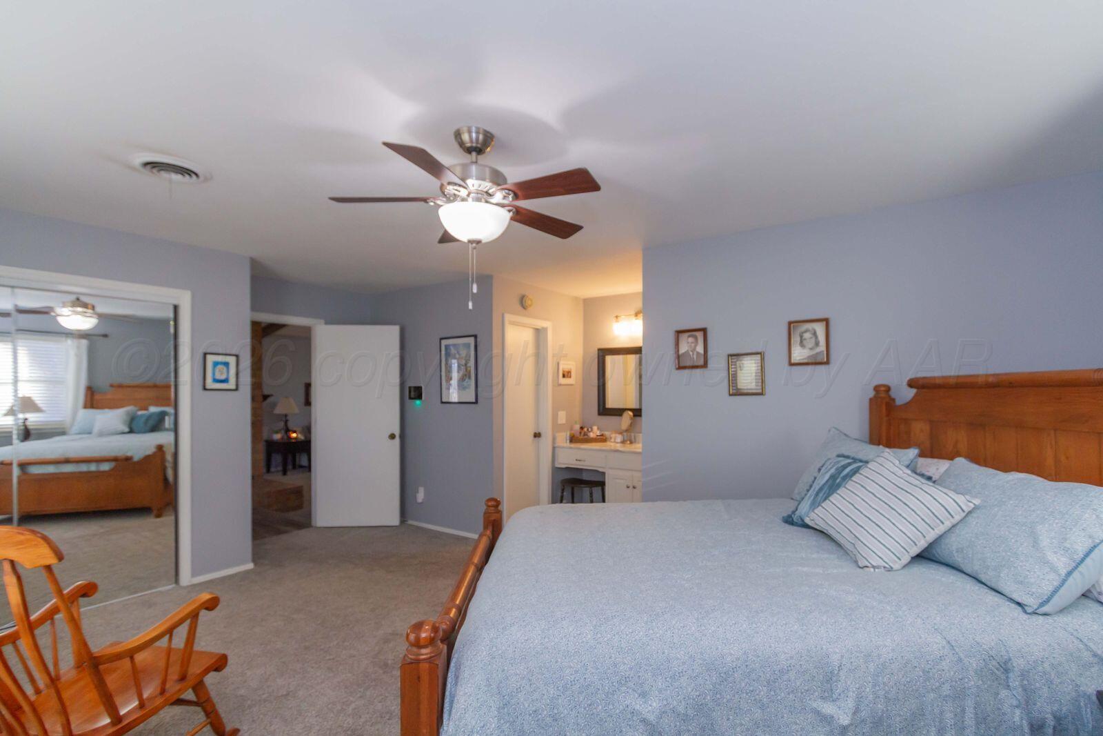7612 Farrell Drive Amarillo, TX 79121 - Photo 15 of 27 a spacious bedroom with a bed and a chandelier