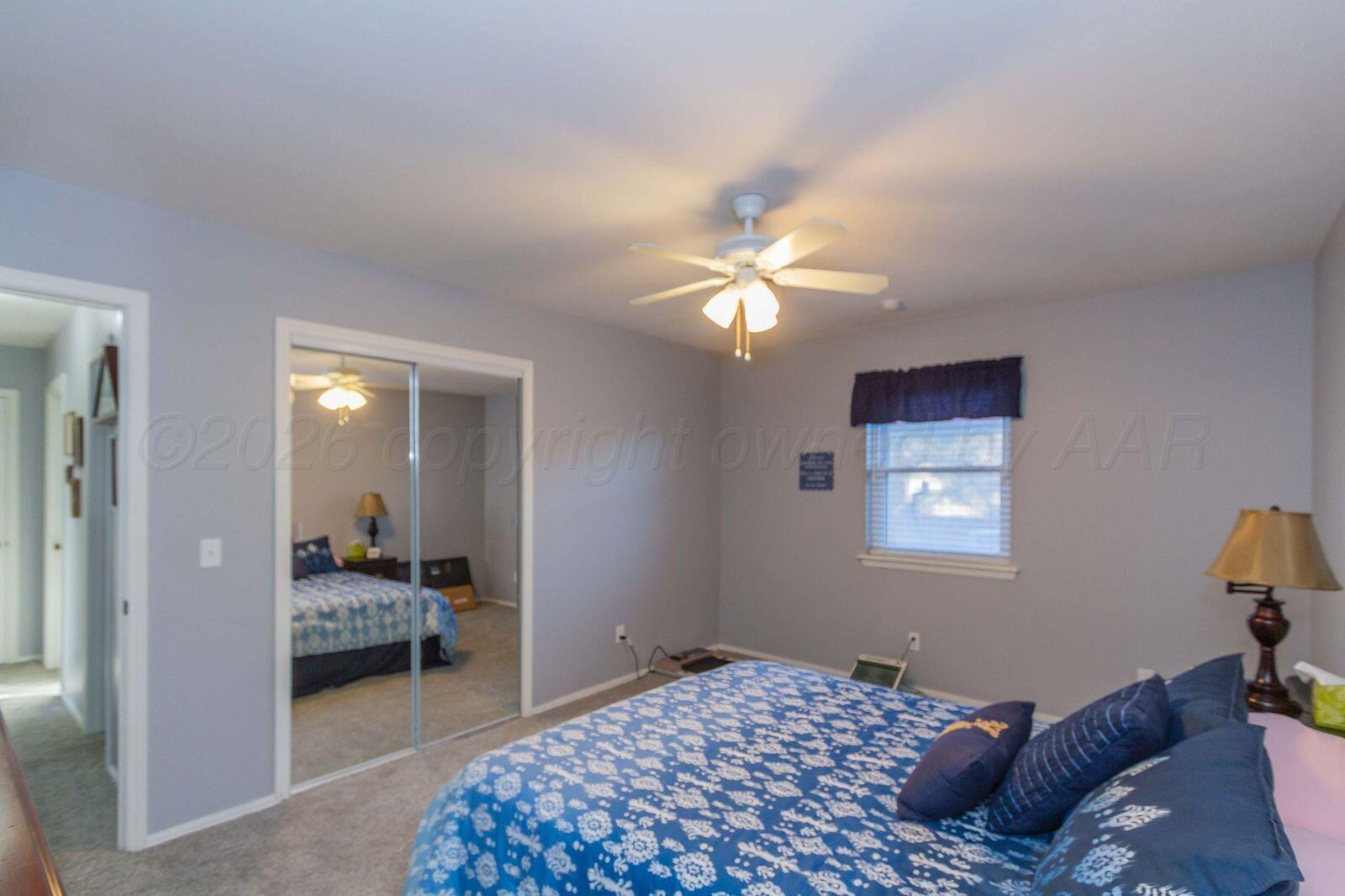 7612 Farrell Drive Amarillo, TX 79121 - Photo 23 of 27 a bedroom with a bed and a chandelier