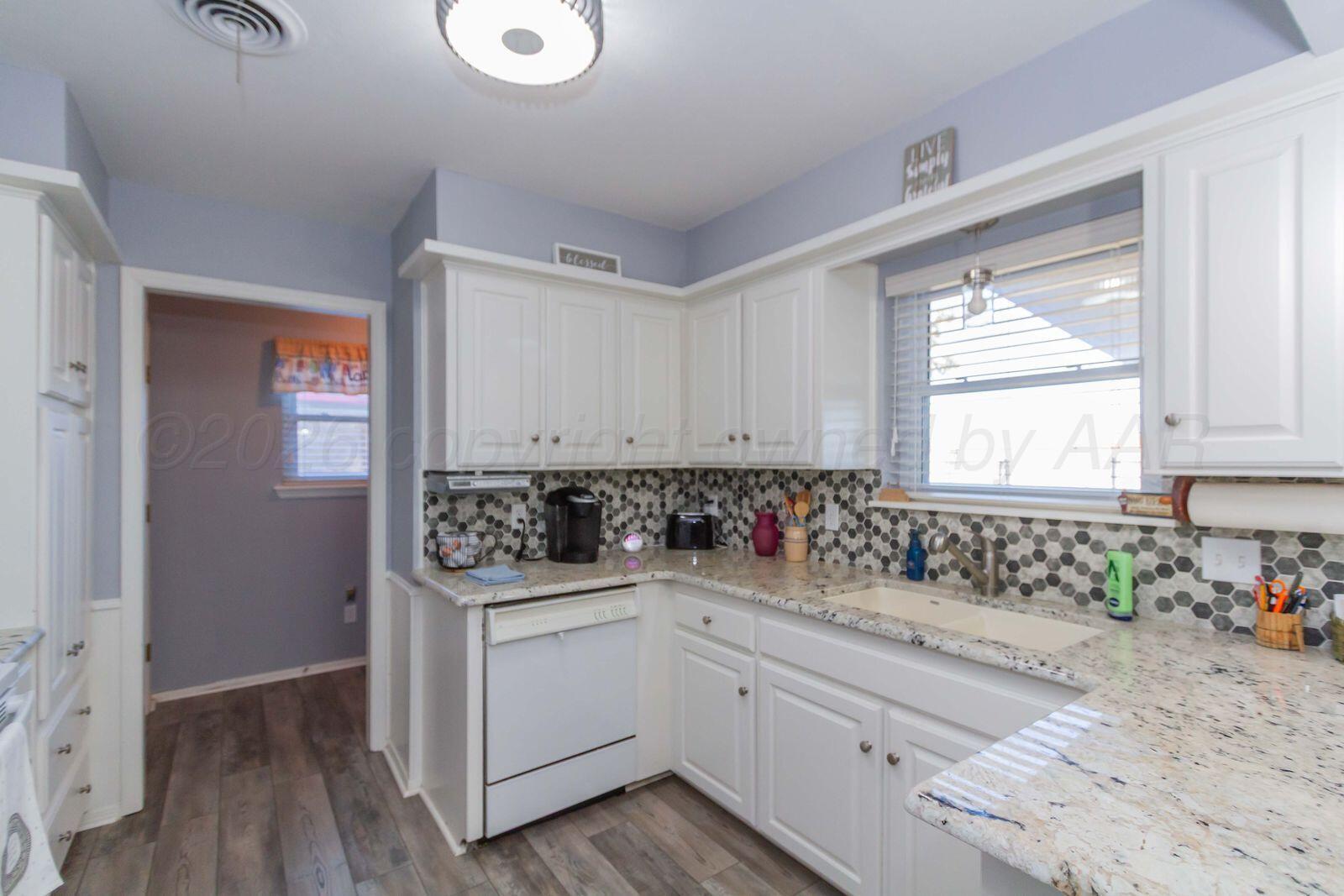 7612 Farrell Drive Amarillo, TX 79121 - Photo 9 of 27 a kitchen with a sink cabinets appliances and a window