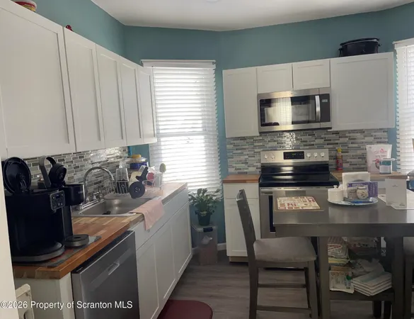 a kitchen with stainless steel appliances granite countertop a stove a sink a microwave a refrigerator and cabinets