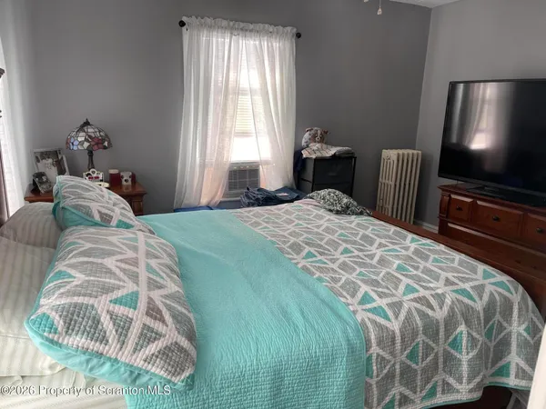 a bedroom with a bed and a flat tv screen
