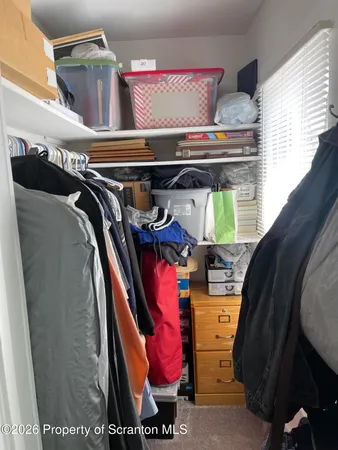 a view of walk in closet with clothes